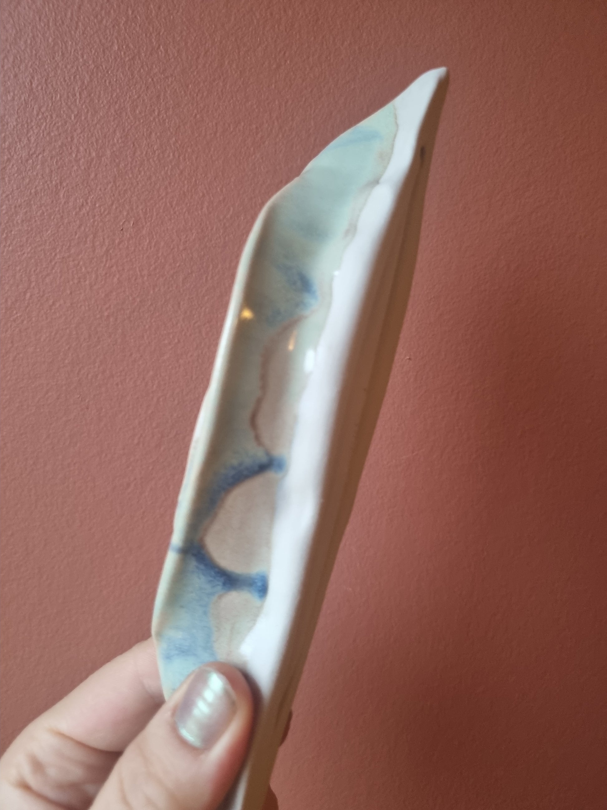Blå porcelæn keramikkusse set fra siden. Holdt i hånden 